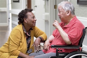 caregiver with an elderly man in a wheelchair